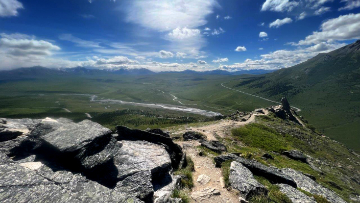 View from a mountain top across a valley on a sunny day.