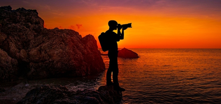 Image of photographer taking a photo at sunset